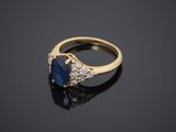 a sapphire and diamond ring on a black surface