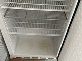 a small refrigerator with a door open on a tiled floor