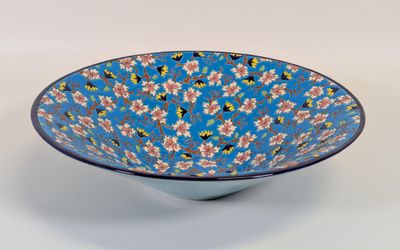 bol bleu et blanc orné de fleurs roses sur fond blanc