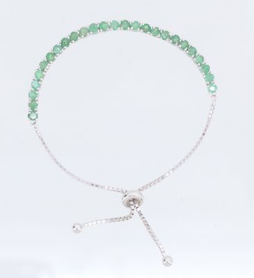 un gros plan d'un bracelet orné de perles vertes sur fond blanc