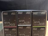 four boxes of makeup products sitting on a wooden table