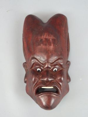 an image of a wooden mask on a wall with a surprised look