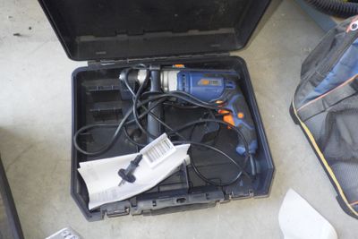une mallette noire posée par terre, contenant des outils