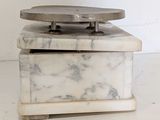a white marble box with a metal lid on a table