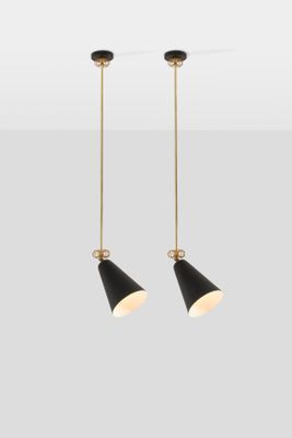 a pair of black and gold pendant lights hanging from a ceiling