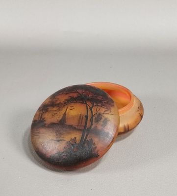a small box with a painting on it sitting on a table