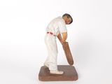 figurine of a man holding a baseball bat on a wooden base