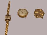 three watches and a watch bracelet on a table