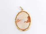 a close up of a gold plated pendant with a woman ' s profile