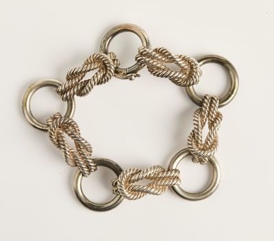 un gros plan d'un bracelet composé d'anneaux métalliques sur un fond blanc