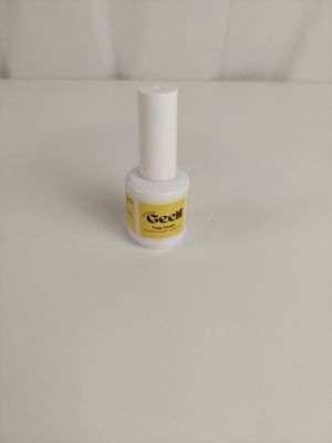 un gros plan d'un flacon de vernis à ongles posé sur une surface blanche