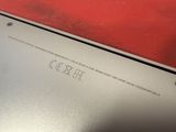 a close up of a silver laptop with a red background