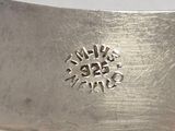 a silver spoon with a flower on it sitting on a table