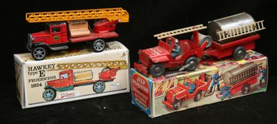 trois camions de pompiers miniatures posés les uns à côté des autres sur un fond noir