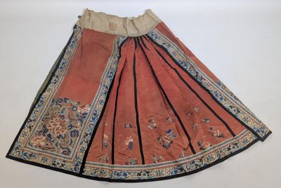 une jupe orange avec des bordures noires et un motif floral sur le bas