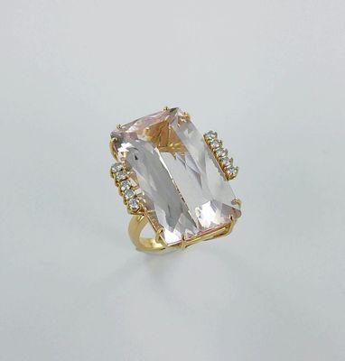 un gros plan d'une bague en or sertie d'une topaze blanche et de diamants
