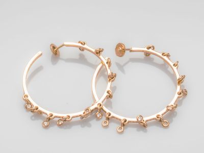 une paire de boucles d'oreilles en or sur fond blanc
