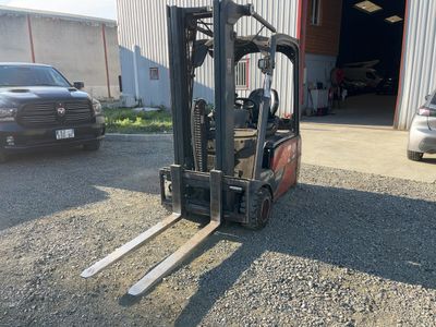 un chariot élévateur garé devant un bâtiment