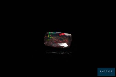 a black oplite stone with a red and green fire in it