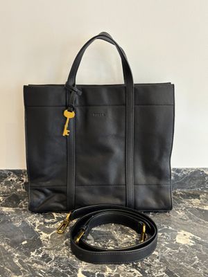 un sac fourre-tout en cuir noir orné d'une clé dorée sur la poignée