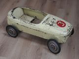une petite voiture miniature posée sur un plancher en bois