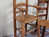 three wooden chairs sitting next to each other in a room