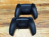 two video game controllers sitting on top of a wooden floor