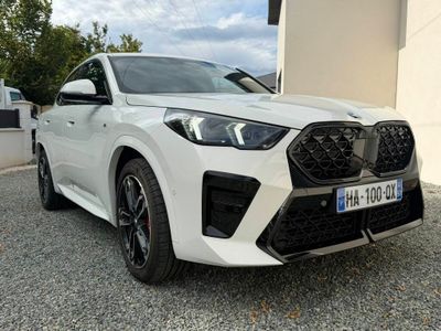 l'avant d'une voiture blanche garée devant un immeuble