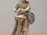 a figurine of a woman with a basket on a table