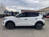 a white suv parked in a parking lot next to a building