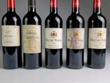 six bottles of wine are lined up in a row on a table