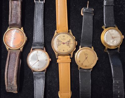 Plusieurs modèles de montres sont exposés dans une vitrine.