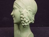 a green statue of a woman with a bird on her head