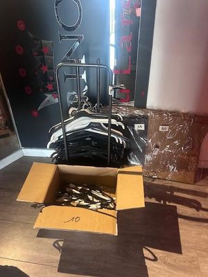 une boîte de vêtements posée par terre à côté d'une pile de vêtements