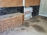 an image of a dirty room with a door and a bench