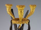 an image of a gold and black vase on a table