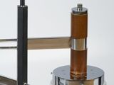 a close up of a glass and metal object on a white surface