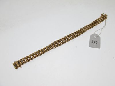 gros plan d'un bracelet en chaîne en or avec une étiquette de prix