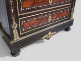 a black and gold chest of drawers with a clock on top of it