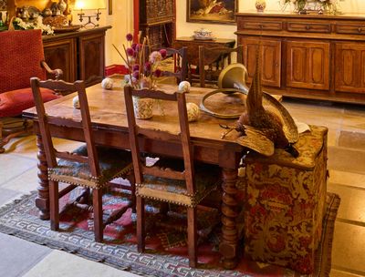 une salle à manger avec une table, des chaises et un buffet