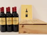 four bottles of red wine in a wooden box next to a card