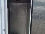 a small refrigerator with a door open in a yard