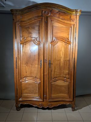 une grande armoire en bois dans le coin d'une pièce