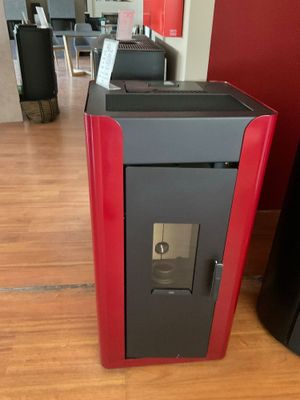 un poêle rouge et noir au milieu d'un parquet
