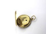 an image of a small gold pocket watch on a white surface