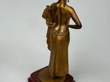 bronze statue of a woman holding a fan on a wooden base