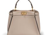 a beige leather handbag with a metal handle