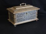 an ornate silver and gold box on a black background