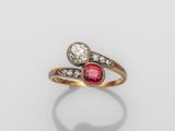 un gros plan d'une bague sertie d'un diamant rouge et blanc sur une surface blanche