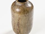 a brown vase that is sitting on a white surface
